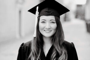 student wearing cap and gown smiling at camera