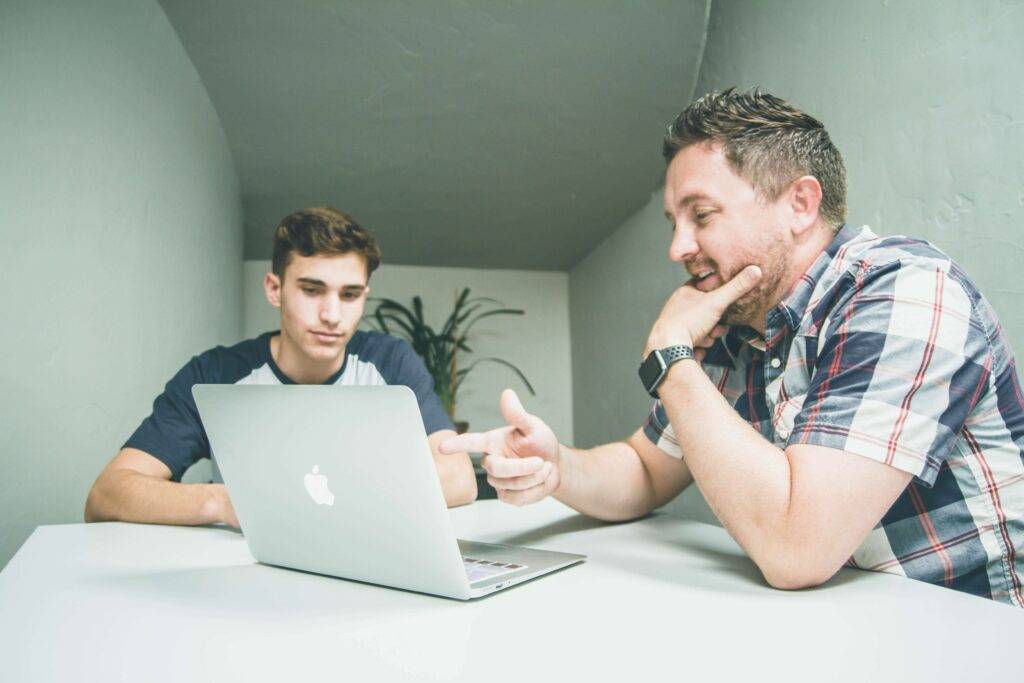 counselor speaking with a student in front of a computer