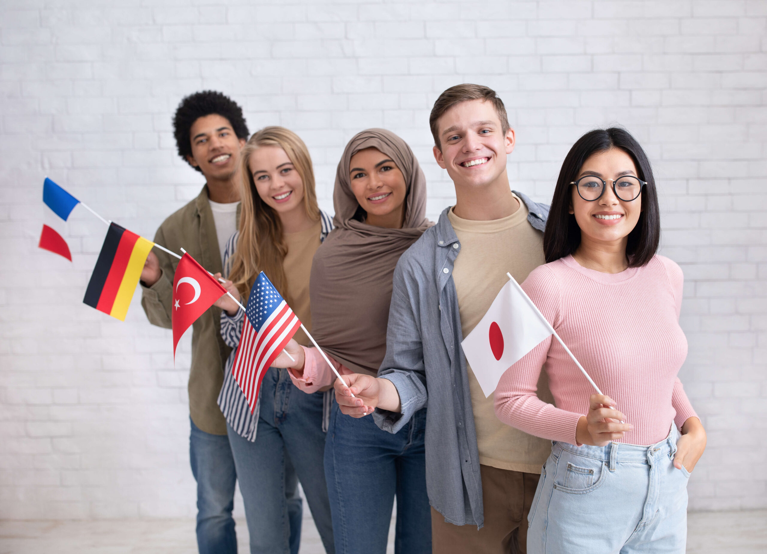 international students standing next to each other holding their country flags