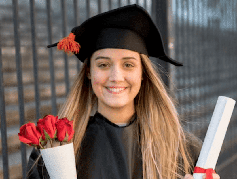 Headshot of Maddie Kearns, wearing a cap and gown, holding flowers and a diploma